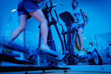 Deportista entrenando en gimnasio sobre bicicleta elíptica.