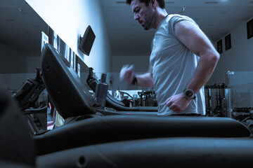 Deportista entrenando en gimnasio sobre cinta de correr.