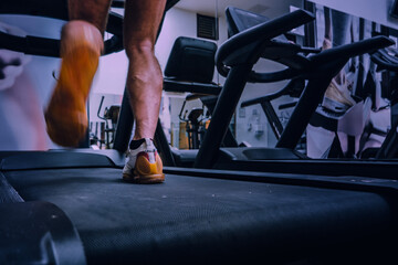 Deportista entrenando en gimnasio sobre cinta de correr.