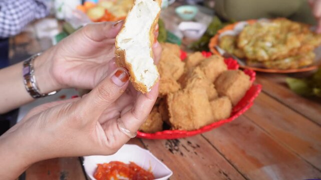 eating together at a tofu restaurant in Sumedang, West Java, Indonesia. Apart from the tofu menu, there are also lontong (sticky rice) and fritters food, serve with sambal or dipping sauce