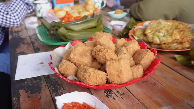 eating together at a tofu restaurant in Sumedang, West Java, Indonesia. Apart from the tofu menu, there are also lontong (sticky rice) and fritters food, serve with sambal or dipping sauce