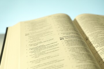 Open Holy Bible in English language on table, closeup