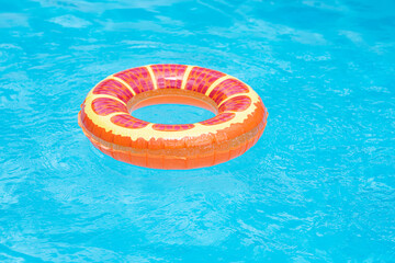 Summer vacation concept. Rubber ring in pool. Colorful inflatable circle ring floating in swimming pool. Summer advertising. Copy space.