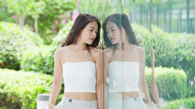 young asian woman leaning on glasswall
