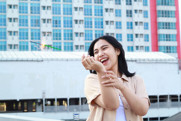 happy asian young woman holding sparklers celebrate new year eve in outdoor roof top with city building background