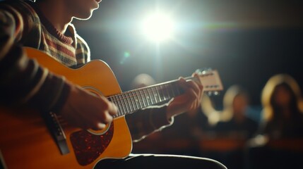 Obraz premium A musician plays an acoustic guitar on stage, illuminated by bright lights, with an audience in the background enjoying the performance.