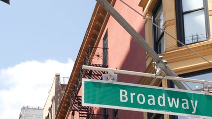 Naklejka premium Broadway street road sign, Manhattan midtown property, house architecture, New York City real estate. Green roadsign on crossroad. Historic district intersection, United States.