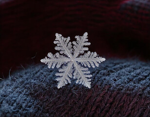 A delicate snowflake rests on a cozy, textured fabric