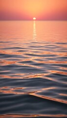 Naklejka premium Sunset Over Calm Ocean with Warm Orange and Pink Reflections