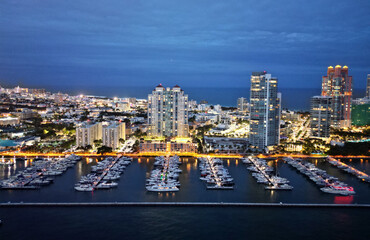 Naklejka premium Summer vacation. Luxury South beach marina. Luxury yacht at night. Miami south beach view. Yacht club. Marina in night Miami. Downtown Miami marina with luxury illuminated yacht. Docked vessels