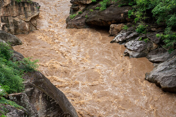 High-pressure flood water in mountain river tributary. A mountain river or stream raging in a flash...