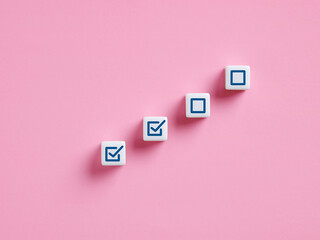 Completing steps towards success: checkmark on cubes symbolizing progress