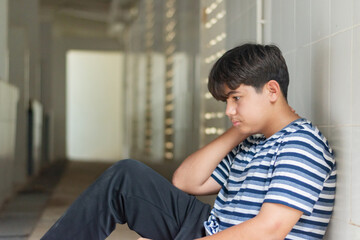 Fototapeta premium Asian early teen is holding metal fence of a locked door and wanting freedom after he was punished by his parents, freedom of child concept.
