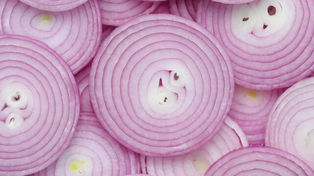 Heap of sliced red onion rotating. Top view shots