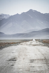 Asphalt road of the Pamir Highway in the valley of the Tien Shan Mountains in Tajikistan in the...