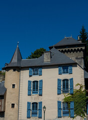 Obraz premium Building with blue shutters and a blue roof. The shutters are open and the building is tall