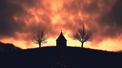Silhouetted church stands majestically on a hilltop, framed by leafless trees against a fiery sunset.