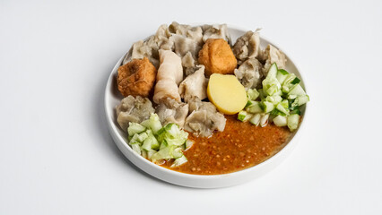 Siomay Bandung (Shumay) or Steamed Siomay. Fish Siomay Served with Peanut Sauce and Chili Sauce on a white background