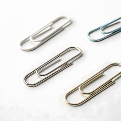 Paper clips in various colors and sizes arranged on plain white background, showcasing their sleek design and functionality. Perfect for office or school use