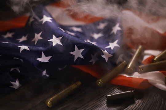 American Flag with Bullet Casings Amid Smoke Symbolizing Conflict and Patriotism