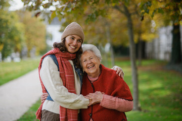 Portrait of a granddaughter on an autumn walk in the park with her grandmother.