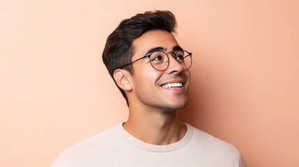 Obraz premium Smiling Hispanic Man with Glasses Against a Peach Background