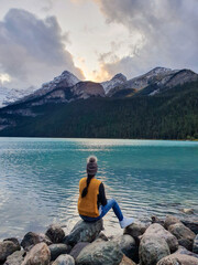 Fototapeta premium Sitting by the tranquil lake at sunset, surrounded by majestic mountains Lake Louise Canada