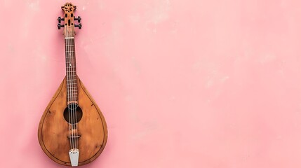 A balalaika positioned against a light pink backdrop