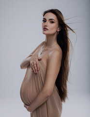 Fototapeta premium beautiful pregnant woman in studio with light drapery like virgin mary