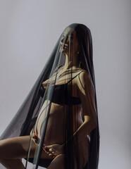 Naklejka premium beautiful pregnant woman in studio under dark veil like virgin mary