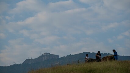 Obraz premium View of three friends making a call on a mountain peak under a clear sky
