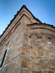 The intricate stonework and distinctive rounded arches of the Saint Nikola church in Dryanovo, Bulgaria, create a captivating architectural tapestry against the backdrop of a clear blue sky.