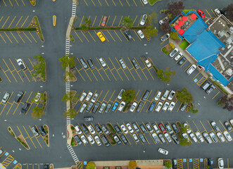A parking lot with many cars and a building in the background © Anton