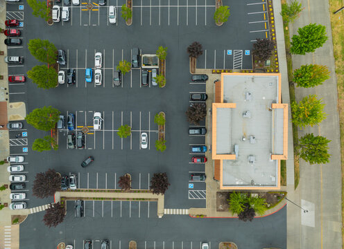A parking lot with a lot of cars and a building in the background