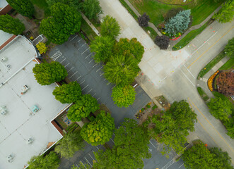 A parking lot with a green tree in the middle © Anton