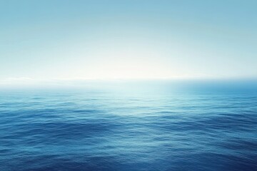 Fototapeta premium A serene, wide-angle view of a calm ocean with a blue sky and a gentle horizon.