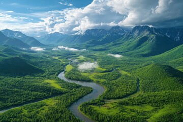 Obraz premium Majestic Aerial View of Serpentine River Flowing Through Lush Green Valley with Snow-Capped Mountains Under a Dramatic Cloudy Sky