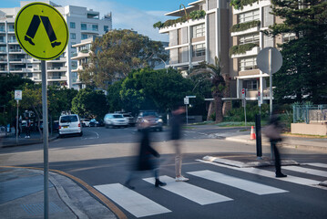 Blurry pedestrians walking across a pedestrian crossing