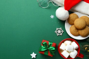 Festive Christmas composition with Santa hat, cookies and hot cocoa with marshmallows on color background