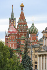View of Orthodox St. Basil's Cathedral from Red Square. Multi-colored domes with Orthodox crosses rise above towers of cathedral. Walls of cathedral are made of red brick