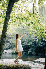A Serene Woman in a Lovely White Dress Gracefully Embracing Natures Beauty Outdoors