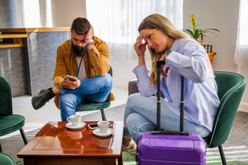Young couple is going on vacation. Tourists sitting at airport cafe because of delayed flight.