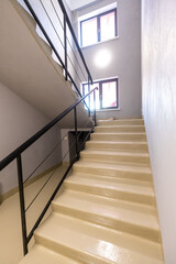 Modern Indoor Stairwell with Beige Steps and Black Metal Railing