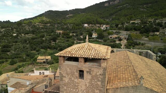 The church tower clock in Estellencs village, Mallorca, Spain. Drone footage. 