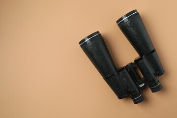 Black binoculars on color background. Top view