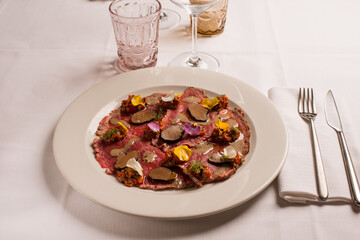 meat carpaccio with sliced truffle and flowers
