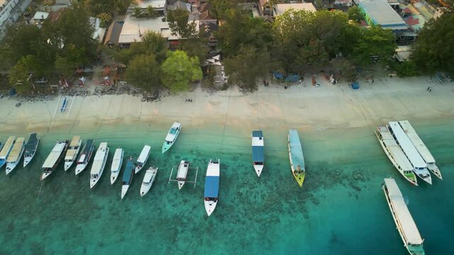 Aerial view of Gilli Trawangan with boats on the turquoise sea and sandy shore, Bali, Indonesia.