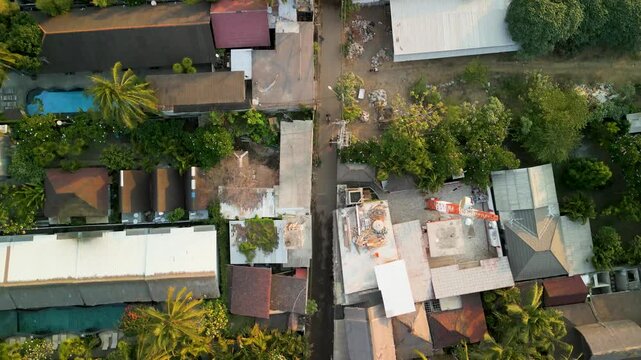 Aerial view of tropical island with lush palm trees and colorful rooftops, Gilli Trawangan, Indonesia.