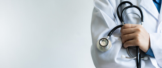 A doctor is holding a stethoscope and wearing a white coat. Concept of professionalism and expertise in the medical field In Hospital