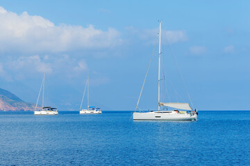 Obraz premium sailing yacht boats with white sails in blue sea , seascape of beautiful ships in sea gulf with mountain coast on background